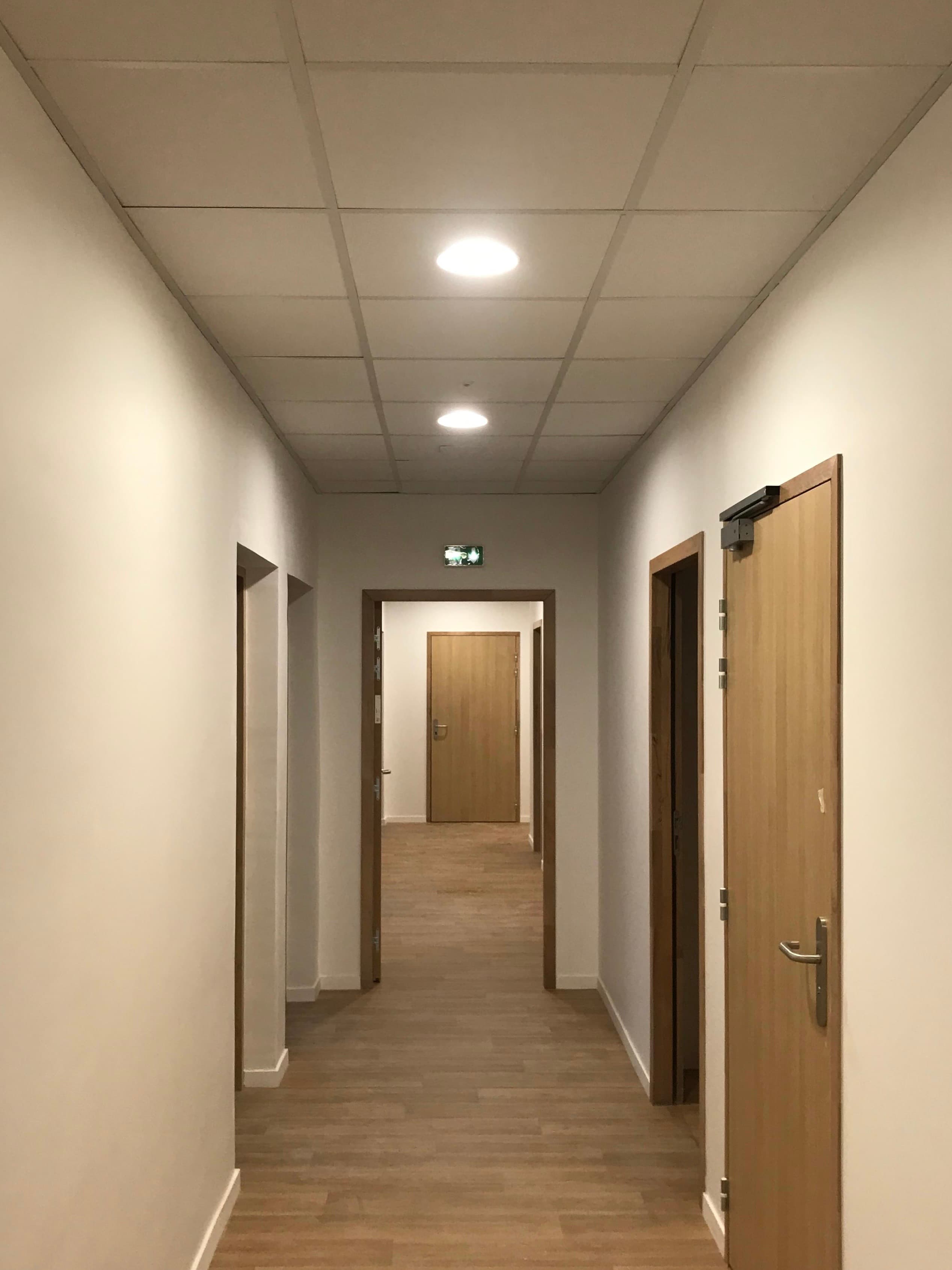 Couloir établissement scolaire avec bloc de sécurité lumineux et luminaire dit downlight